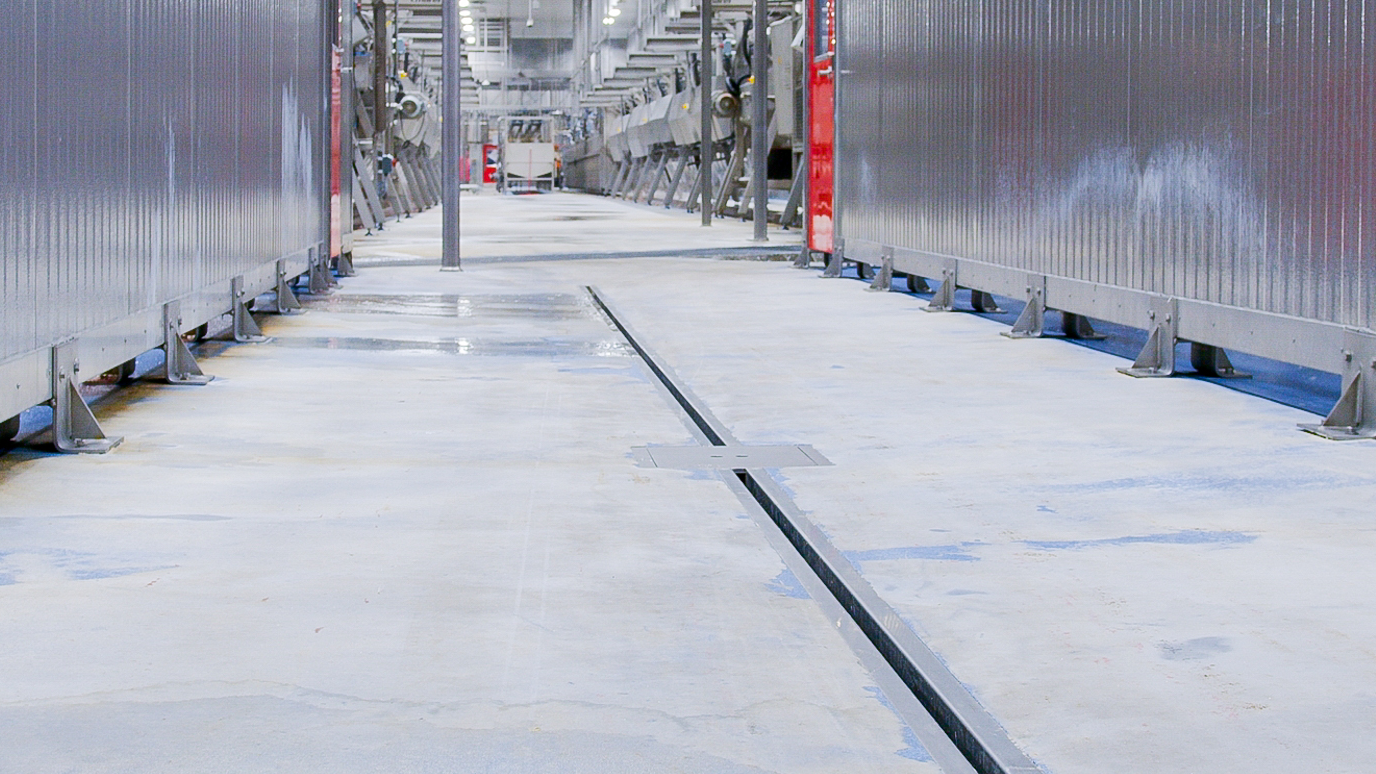 Slot Drain runs along the middle of a hallway in a sanitary food processing facility.